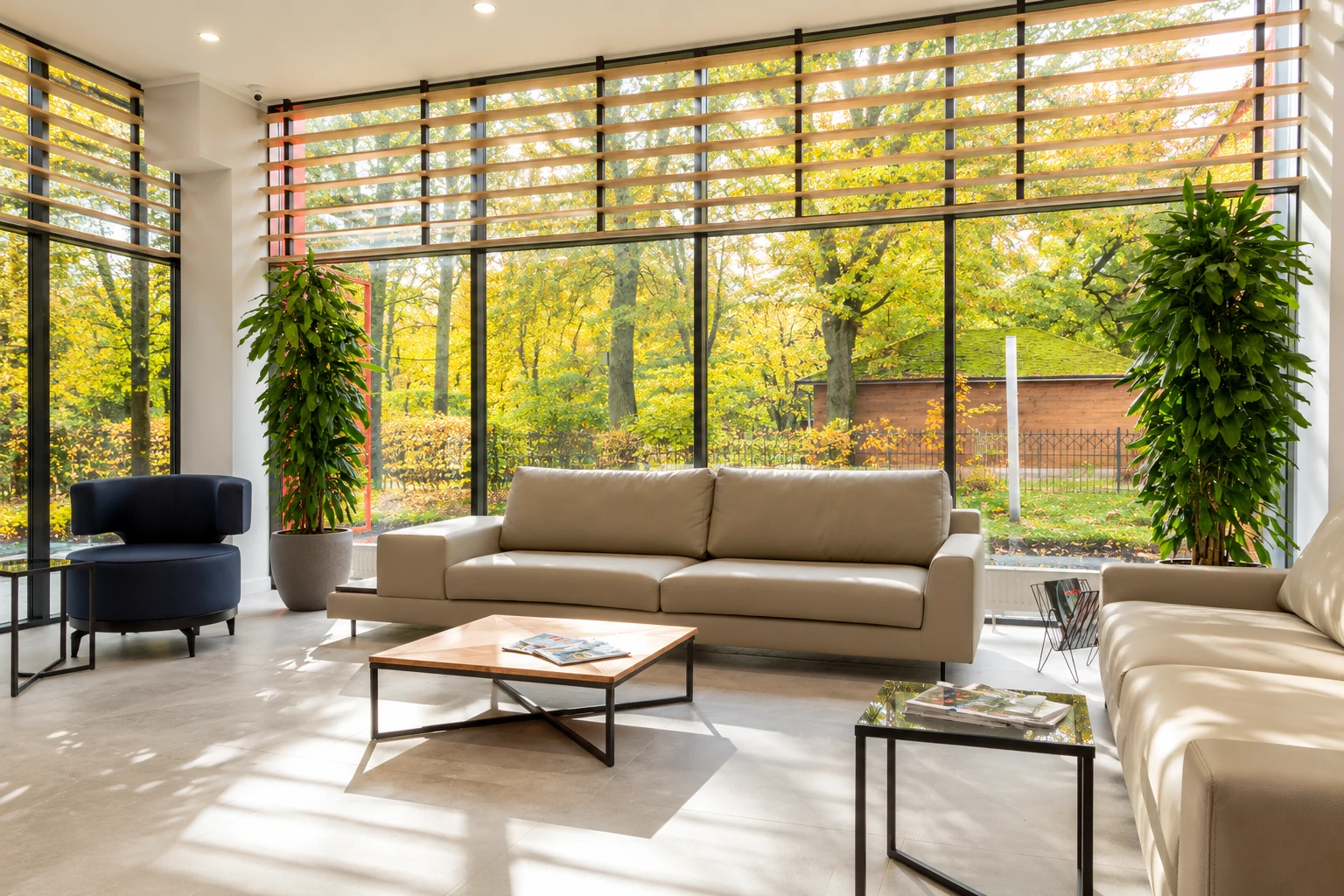 Modern all-season sunroom with floor-to-ceiling windows, horizontal wood slats, sofas and views of autumn trees.